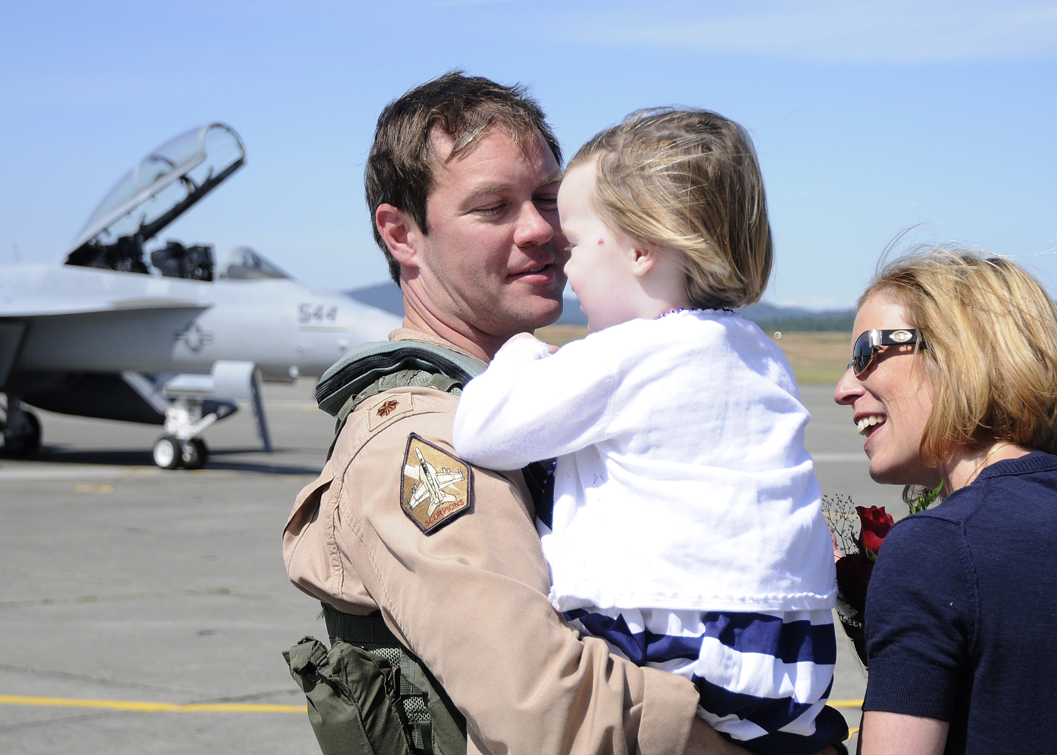 US Navy 110709-N-ZK021-011 Lt. Cmdr. Robert Scott is greeted by family during a homecoming ceremony at Naval Air Station Whidbey